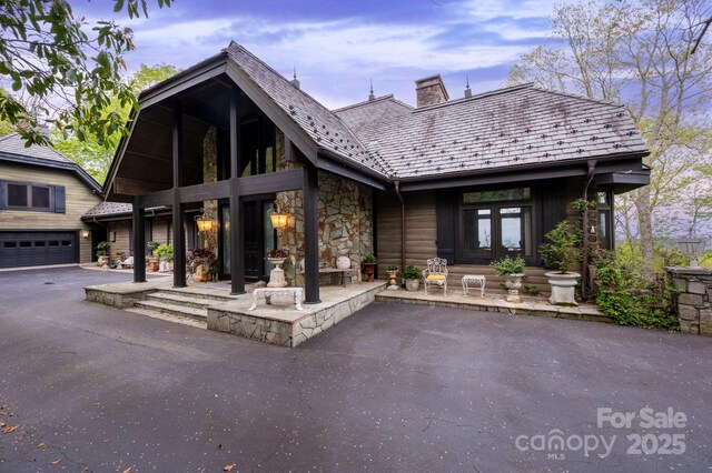 1052 Toxaway Dr, Lake Toxaway, NC 28747 - rear view of property with a chimney, stone siding, and french doors