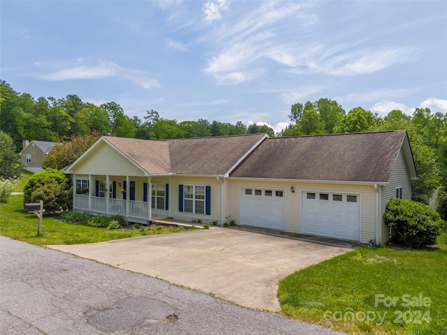 ranch-style house featuring a garage, a front lawn, and a porch