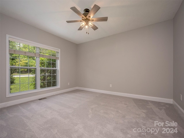 spare room featuring a healthy amount of sunlight, ceiling fan, and carpet flooring