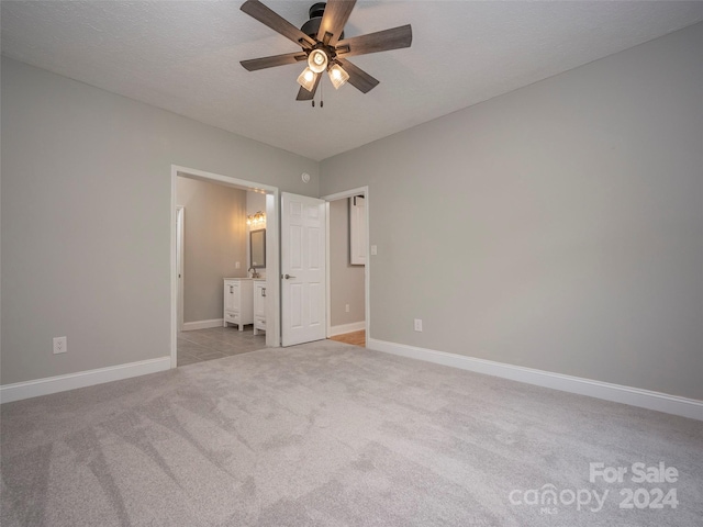 unfurnished bedroom featuring carpet, ceiling fan, and sink