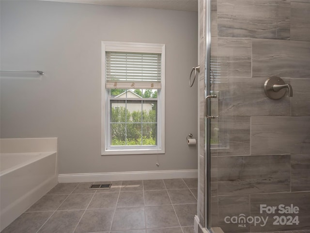 bathroom featuring tile flooring and separate shower and tub