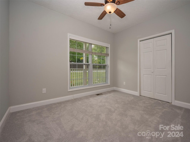 unfurnished bedroom with a closet, ceiling fan, and carpet