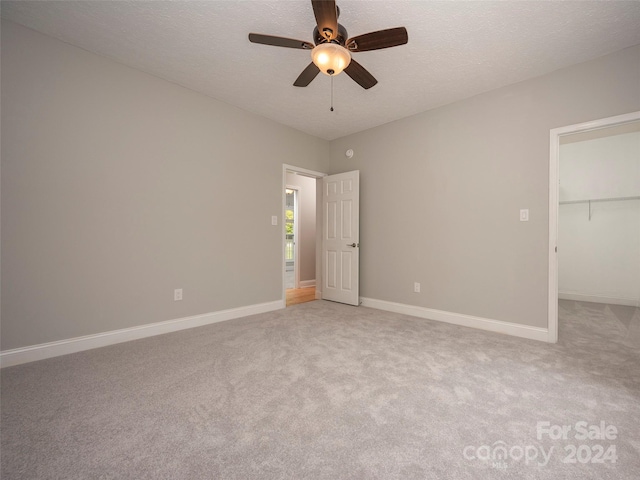 interior space with a textured ceiling and ceiling fan