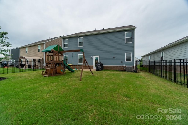 back of property featuring a playground, a yard, and central AC