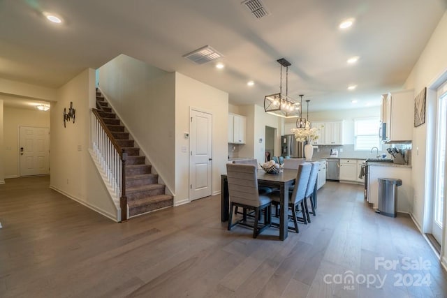 dining area with sink, dark hardwood / wood-style flooring, and a notable chandelier