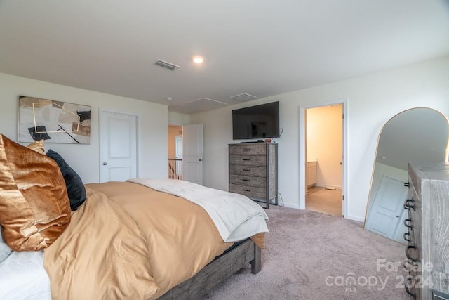 bedroom featuring light carpet and ensuite bathroom