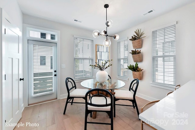 dining room with light hardwood / wood-style floors and a chandelier