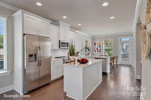 kitchen featuring pendant lighting, a kitchen island, dark hardwood / wood-style flooring, appliances with stainless steel finishes, and white cabinetry