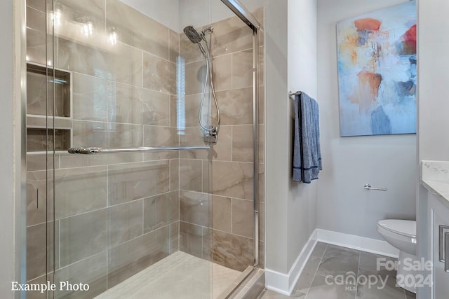 bathroom with vanity, toilet, an enclosed shower, and tile patterned floors