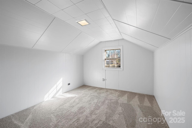 additional living space featuring vaulted ceiling and carpet floors