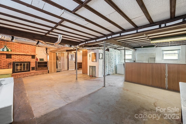 basement featuring washer / dryer and a brick fireplace