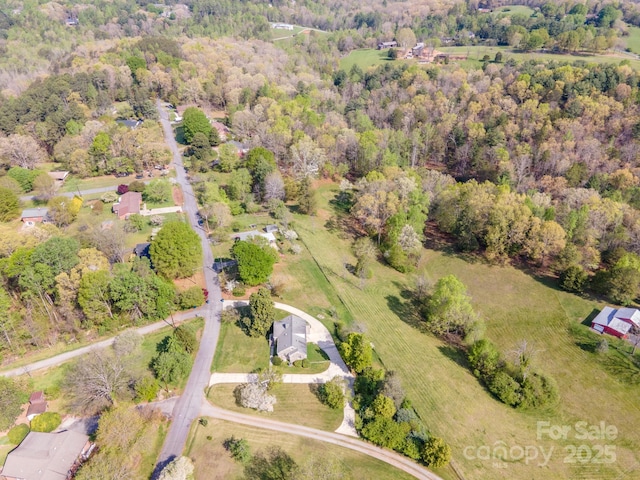 birds eye view of property with a view of trees