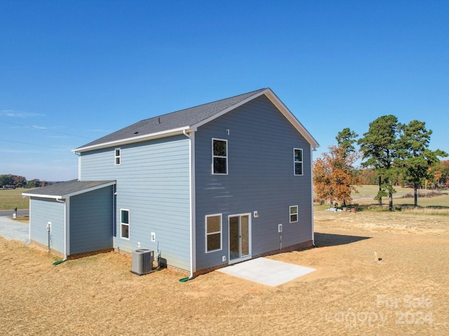 rear view of house with central AC unit and a patio