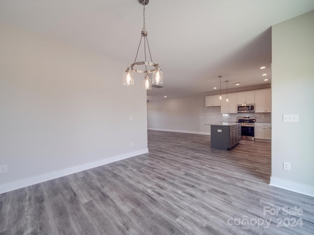 unfurnished living room featuring a chandelier and light hardwood / wood-style floors