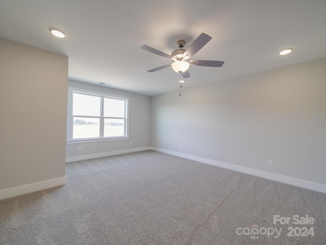 carpeted spare room featuring ceiling fan