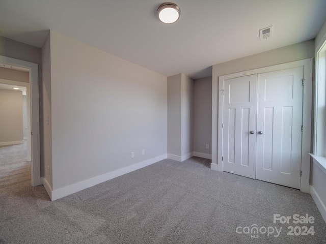 unfurnished bedroom featuring carpet and a closet