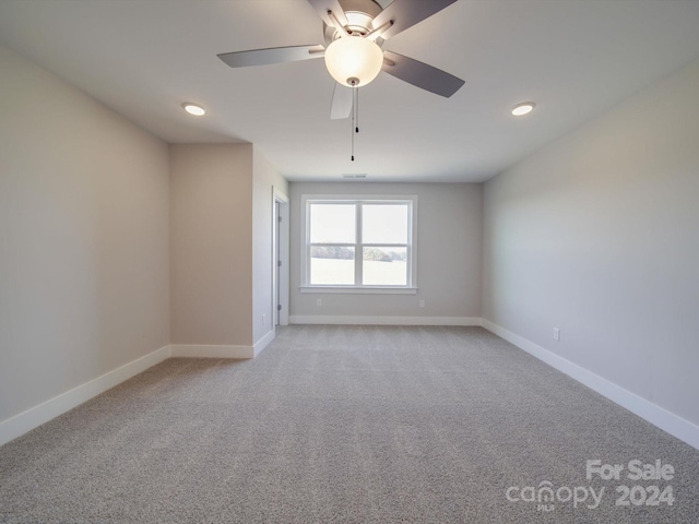 carpeted spare room with ceiling fan