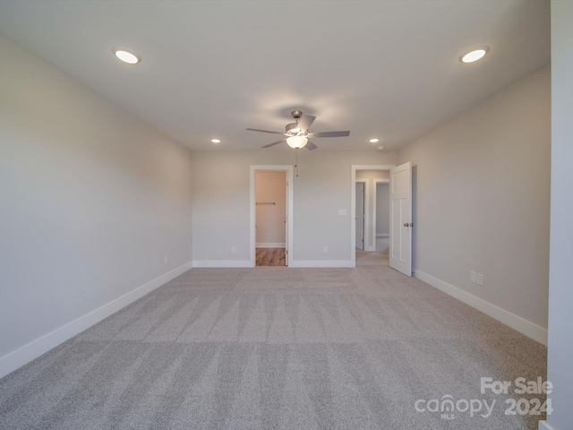 carpeted spare room featuring ceiling fan