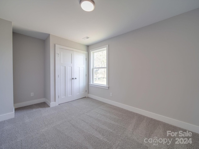 unfurnished bedroom featuring a closet and carpet