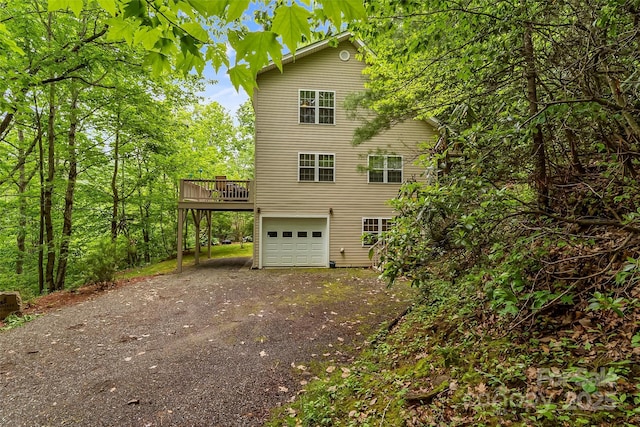 view of side of property featuring a wooden deck and a garage