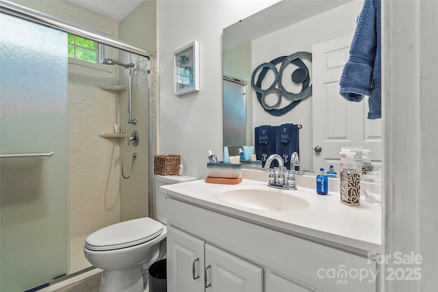 bathroom featuring toilet, vanity, and a shower with shower door