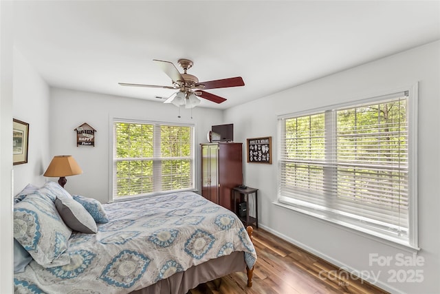 bedroom featuring multiple windows, hardwood / wood-style flooring, and ceiling fan