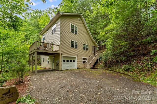 view of side of home with a wooden deck and a garage