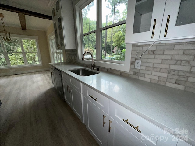 kitchen featuring dark hardwood / wood-style floors, tasteful backsplash, sink, white cabinets, and dishwashing machine