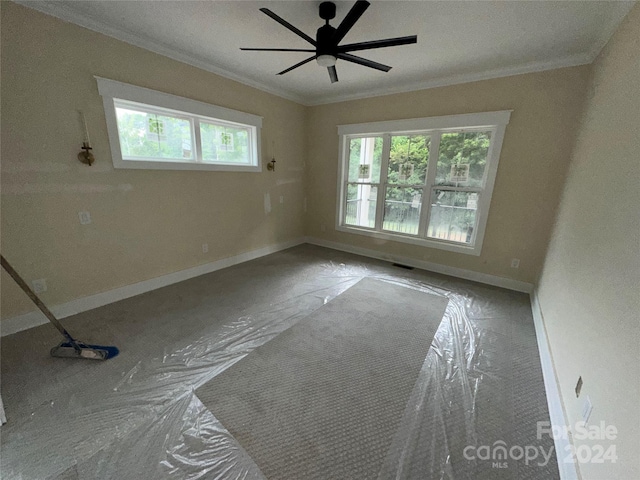 unfurnished room featuring ceiling fan and ornamental molding