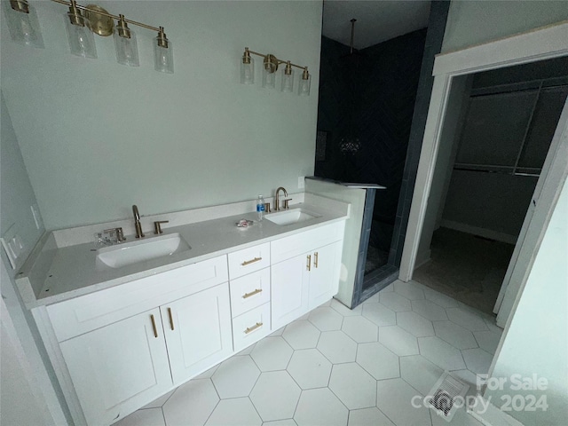 bathroom with a shower, tile patterned floors, and vanity