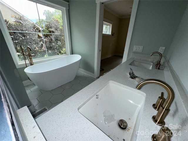 bathroom with a bathing tub, crown molding, tile patterned floors, and vanity