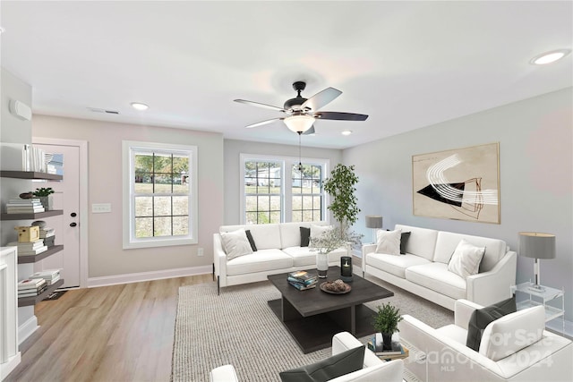 living room with ceiling fan and light hardwood / wood-style flooring