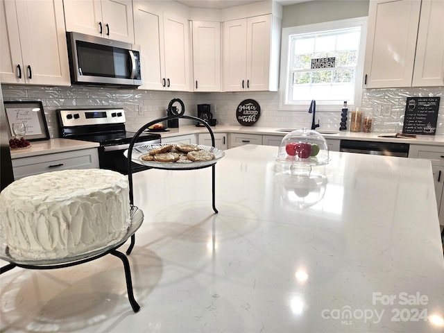 kitchen with white cabinetry, stainless steel appliances, and sink