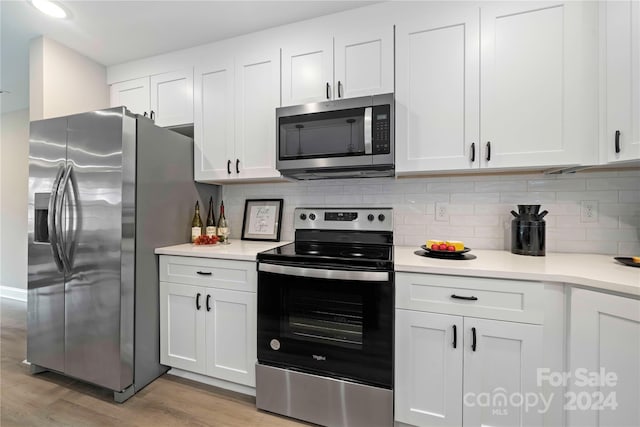 kitchen featuring white cabinetry, light wood-type flooring, appliances with stainless steel finishes, and tasteful backsplash