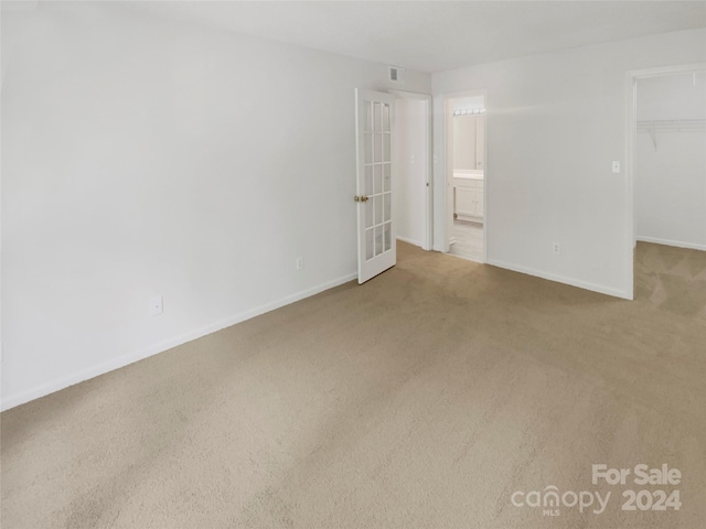 unfurnished bedroom featuring a spacious closet, a closet, and carpet