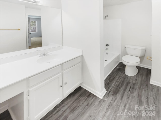 full bathroom with shower / washtub combination, vanity, hardwood / wood-style flooring, and toilet