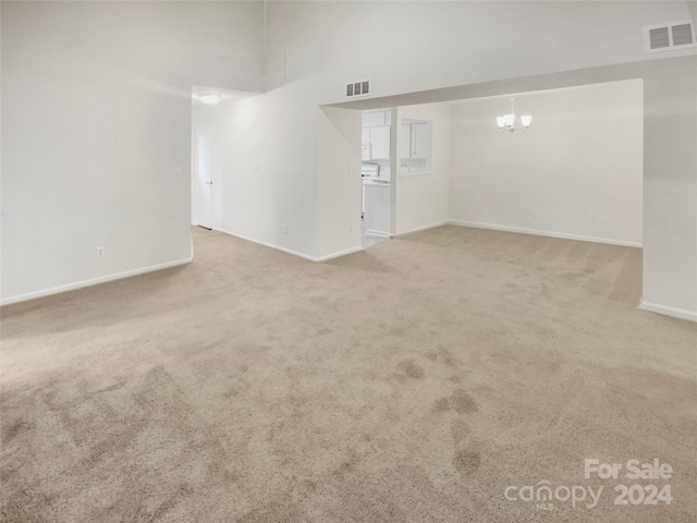 carpeted empty room featuring a chandelier