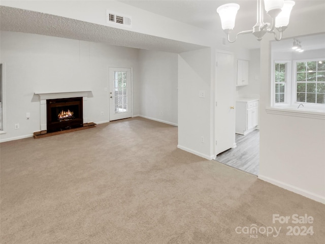 unfurnished living room with light carpet and a notable chandelier