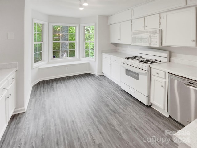 kitchen with hardwood / wood-style flooring, white cabinets, and white appliances