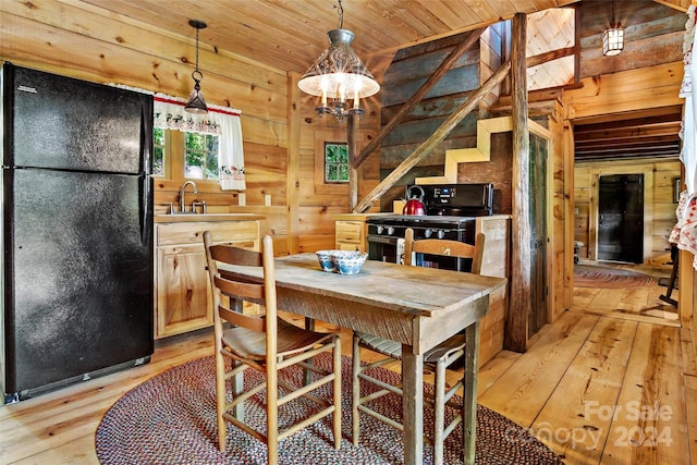 dining area with sink, light hardwood / wood-style floors, wood walls, and wooden ceiling