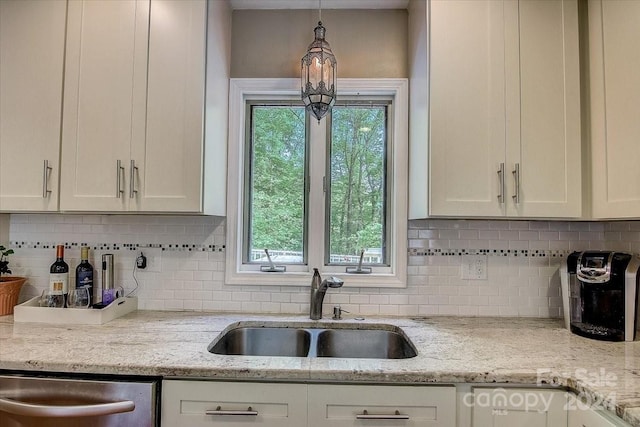 kitchen with sink, white cabinetry, and light stone counters