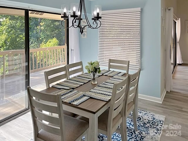 dining room with a wealth of natural light, hardwood / wood-style floors, and a notable chandelier