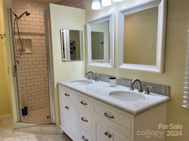 bathroom with a shower with shower door, tile flooring, and double sink vanity