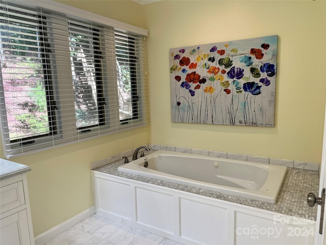 bathroom featuring a tub, vanity, and tile flooring