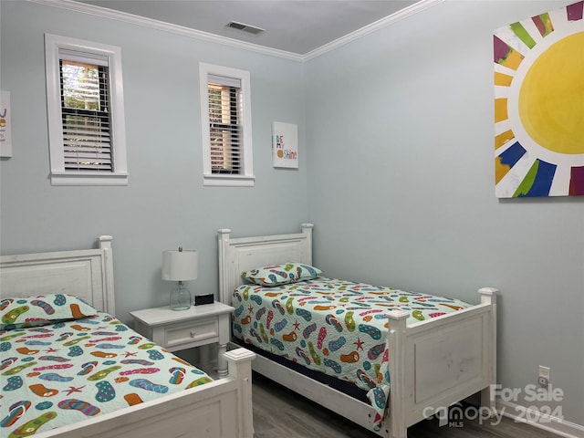 bedroom featuring dark wood-type flooring and crown molding