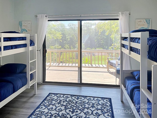 bedroom featuring multiple windows, access to outside, and dark wood-type flooring