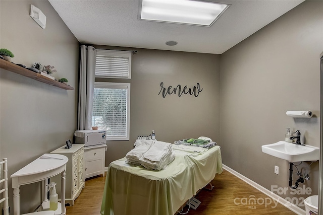 bedroom featuring hardwood / wood-style floors and sink