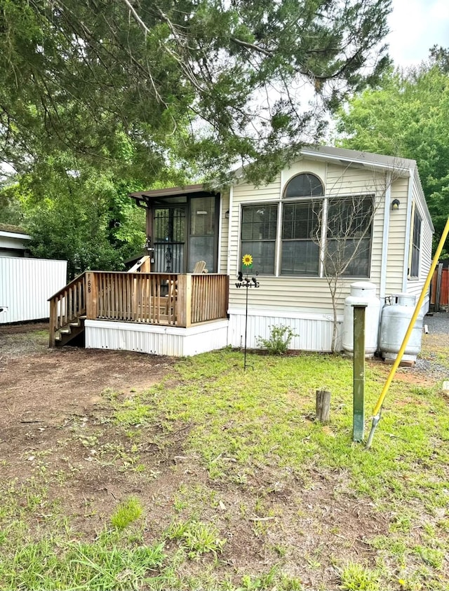 view of front of property featuring a front yard and a deck