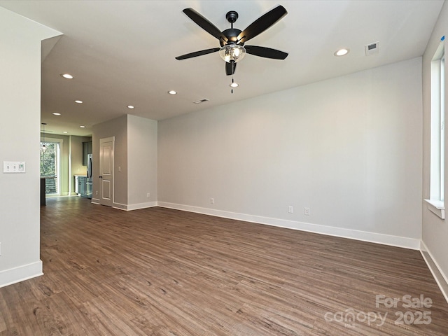 spare room with baseboards, dark wood finished floors, visible vents, and recessed lighting