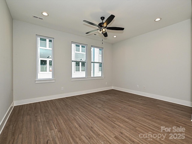 empty room with dark wood finished floors, recessed lighting, visible vents, a ceiling fan, and baseboards